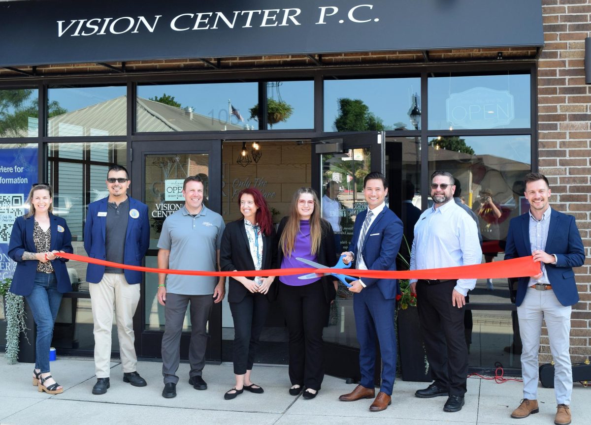Staff and representatives from Greater Iowa City, Inc. gather before Dr. Ian Hui cuts the ribbon during the grand opening of Vision Center P.C. Tuesday, August 5 in downtown Solon.