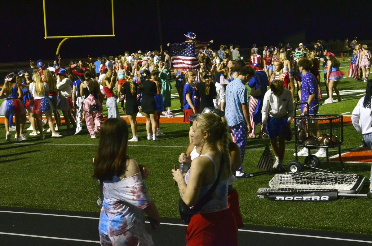 Students dressed in red, white, and blue, and other patriotic attire swarm the field after the 35-20 varsity football win over archrival Mount Vernon Friday, Sept. 12 on Armed Forces Night.
