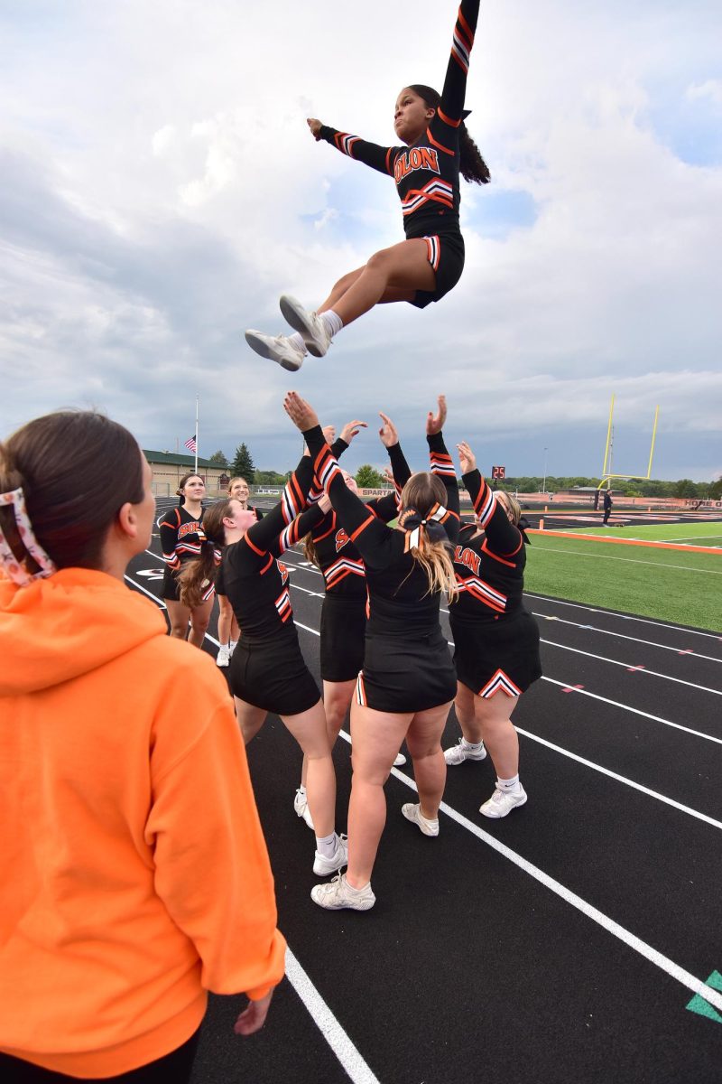 Coach Elizabeth Rohner keeps a watchful eye as a team of cheerleaders launches Layla Knazze skyward while practicing before the start of the varsity football game Friday, August 29. Rohner and co-coach Kashi Griffith have 20 girls on the squad this season.