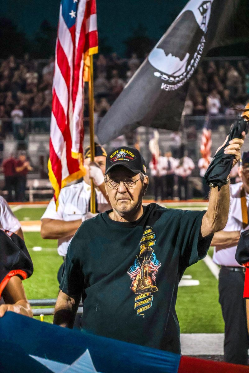 Jim Croy waves to the crowd after being introduced as the 2025 Veteran of the Night Friday, Sept. 12 during pregame ceremonies of the Solon vs. Mount Vernon varsity football game.