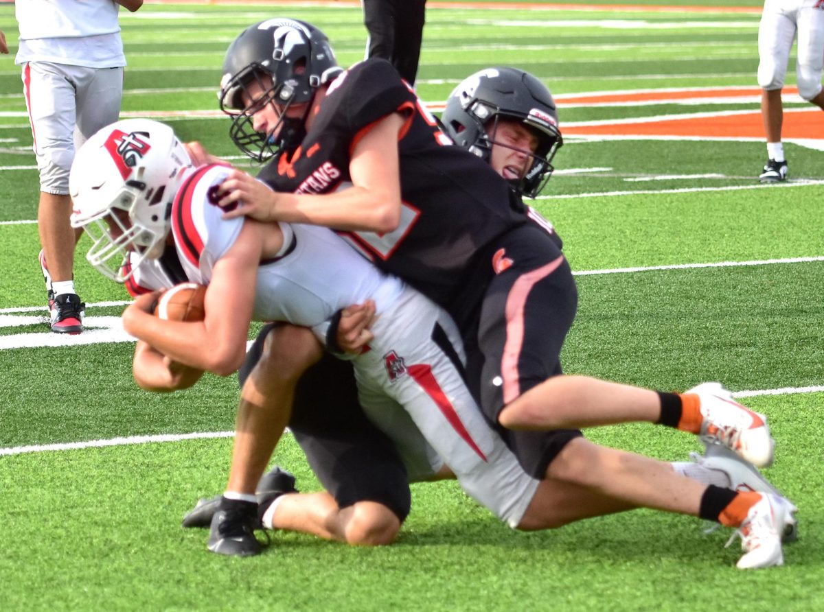 Hudson Pauley (front) and Mac Svalstad bring down an Assumption Knight Friday, August 29 in the frosh-soph game. Solon shut out the Assumption Knights 8-0.
