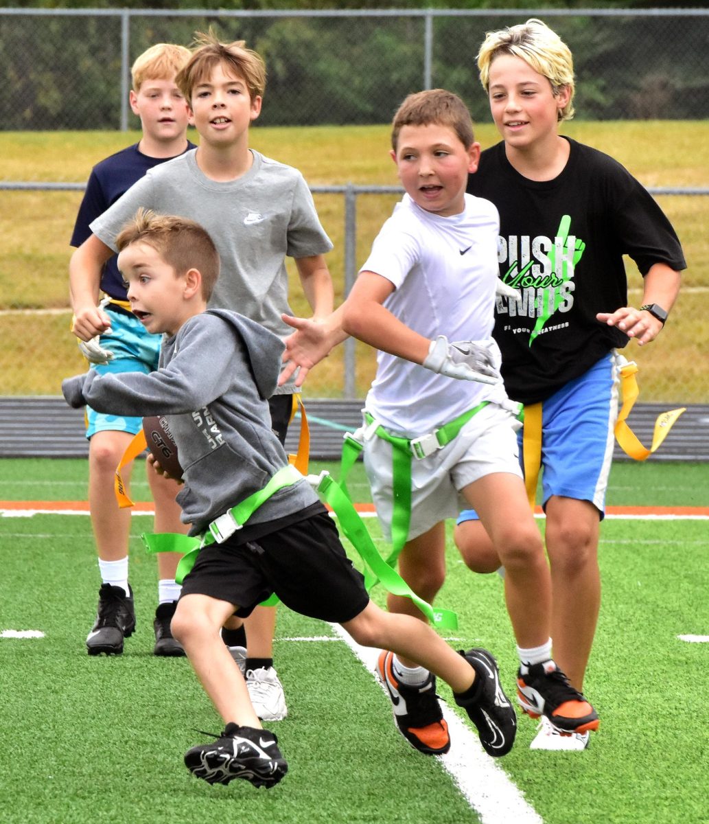 Emmett Swancutt, a 2nd grade student, runs a play for the 5th grade green team during the Flag Football Tournament Saturday, Sept. 20 in Spartan Stadium.