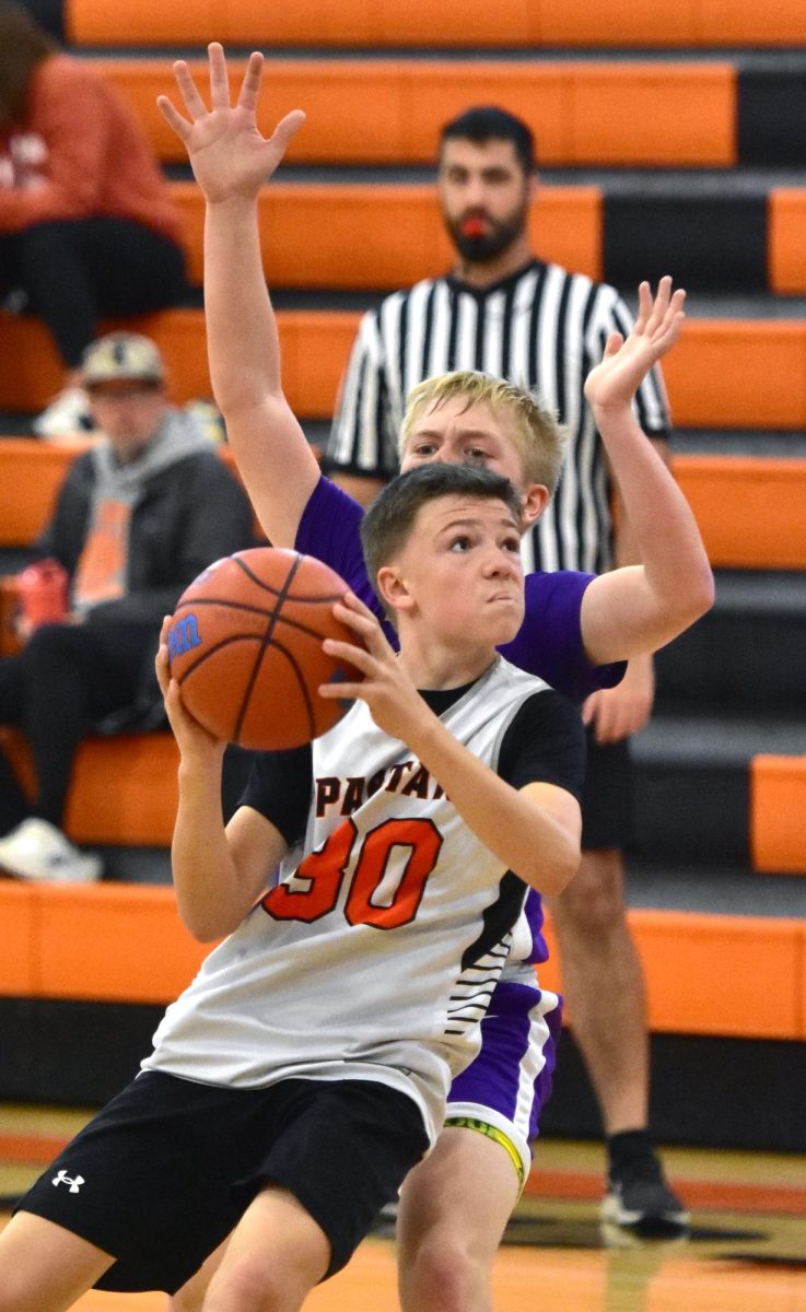 Teegan Pataska lines up a shot under pressure from a Muscatine Muskie Sunday, Nov. 2 during 7th grade competition in the annual Youth Basketball Tournament at the high school. Teams from third-through-eighth grade competed at the high school, middle school, and intermediate school.