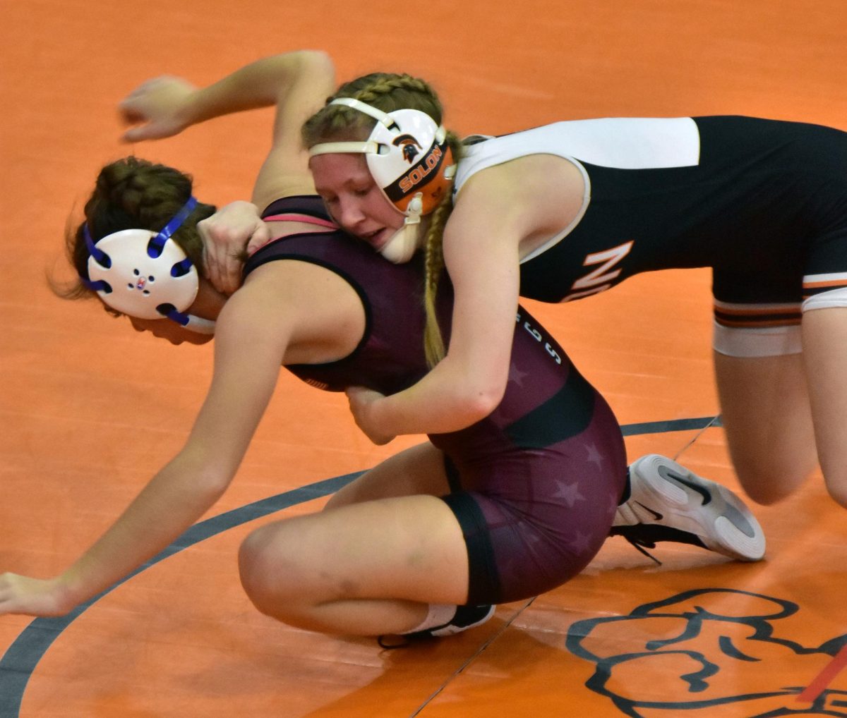Tess Richards works to bring down Independence’s Morgan Krall in the varsity 120-lb. match Friday, Dec. 12. Krall ended up winning the match by fall in 4:17.