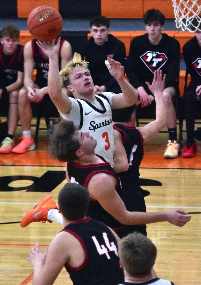 Maddox Kelley (3) battles to put up a two-point shot Tuesday, Jan. 6 at home as the Spartans dismantled the Williamsburg Raiders on the hardwood.