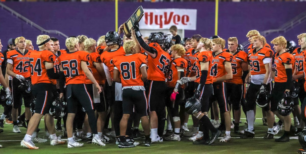 The Spartans hold up their Class 3A State Tournament Participant trophy for family and fans to see after falling 29-10 to Nevada in the Semifinals Saturday, Nov. 15 in the UNI-Dome in Cedar Falls.