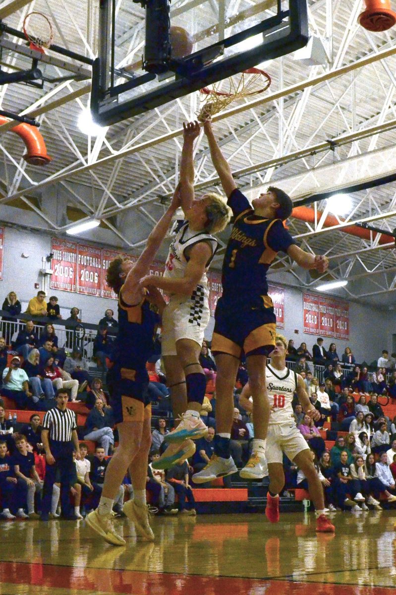 Ethan Ulch, a senior, goes up for two points sandwiched between a pair of Vinton-Shellsburg Vikings. The Spartans outlasted their visitors 61-53 with six points from Ulch Tuesday, Feb. 10.