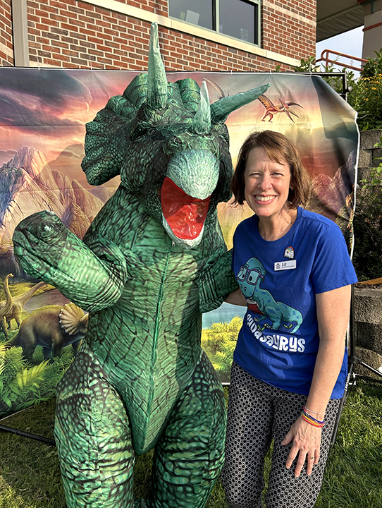 Solon Public Library Director Liz King poses with the Library’s mascot, Trixie The Triceratops, at the August 2025 Dinos at Dusk Program.