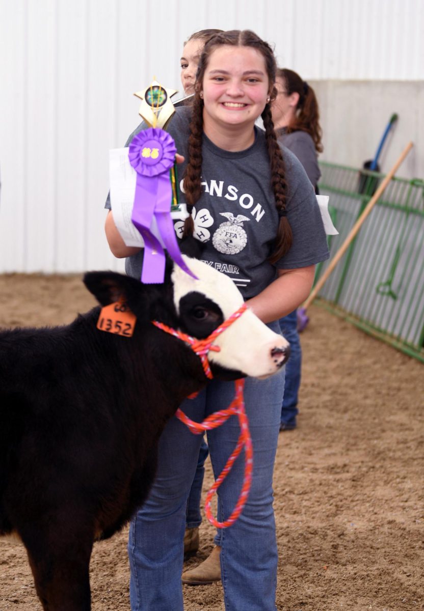 Freshman Autumn Miller, a member of the Graham Champions 4-H Club, poses with her bucket bottle calf trophy at the 2025 Johnson County Fair