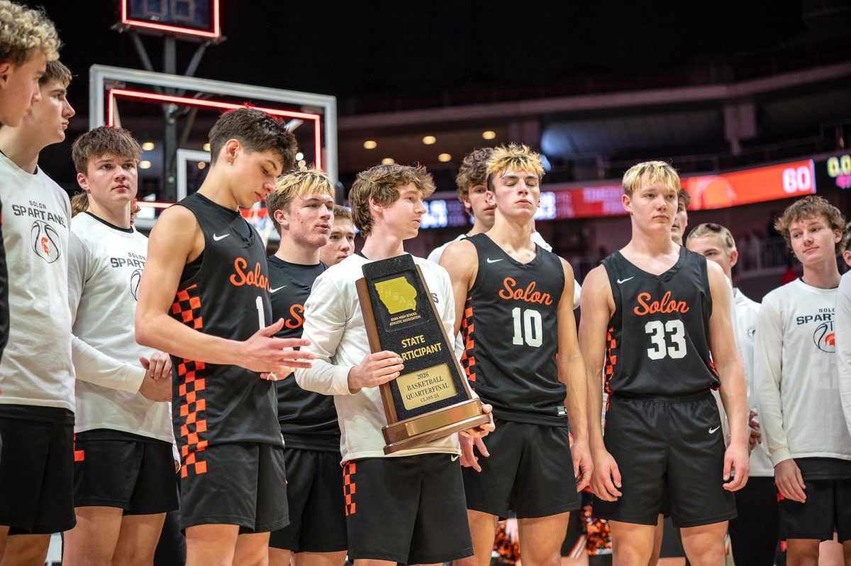 The Solon Spartans stand with their 2026 Class 3A State Tournament Participant trophy Monday, March 9, after falling 68-60, in overtime, to the Storm Lake Tornadoes at the Casey’s Center in Des Moines.