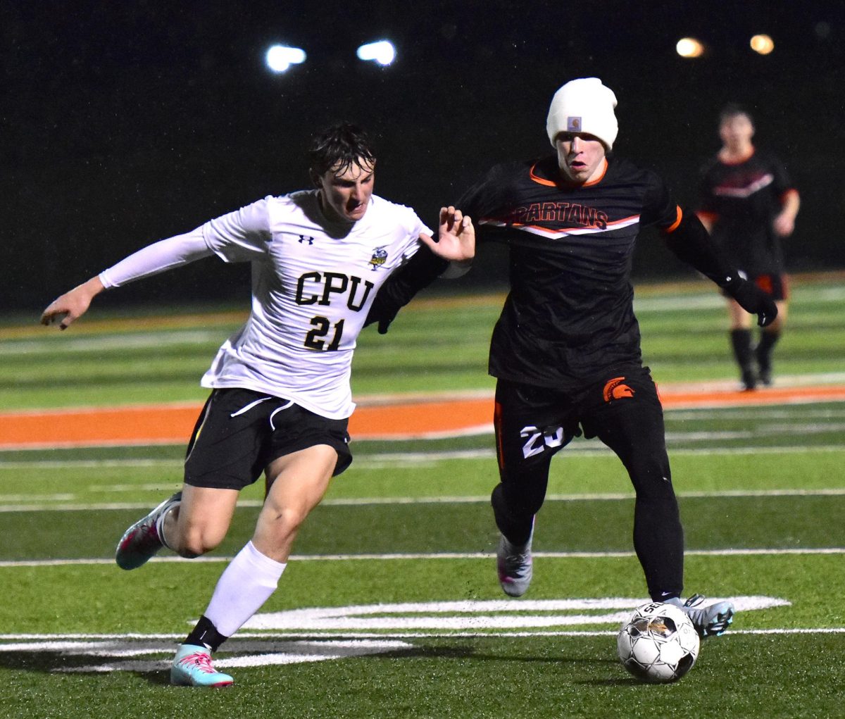 CPU’s Ben Hutchins (21) and Trendon Walker (26) fight for the ball as the rain continues to fall Thursday, April 9, in Solon. The Spartans and Stormin’ Pointers battled to a soggy 0-0 ending.