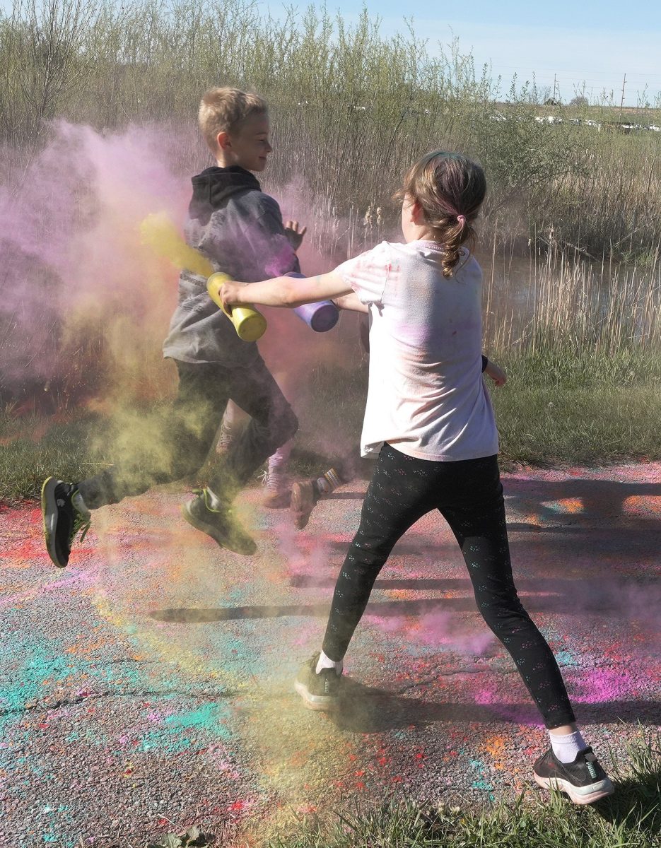 A volunteer blasts a runner with colored powder in the Spartan Decontamination obstacle during the 2025 Spartan Dash at the Solon Recreation and Nature Area. The annual event raises money for the PTOs at Lakeview Elementary and the Solon Intermediate School and will be held again Saturday, April 25