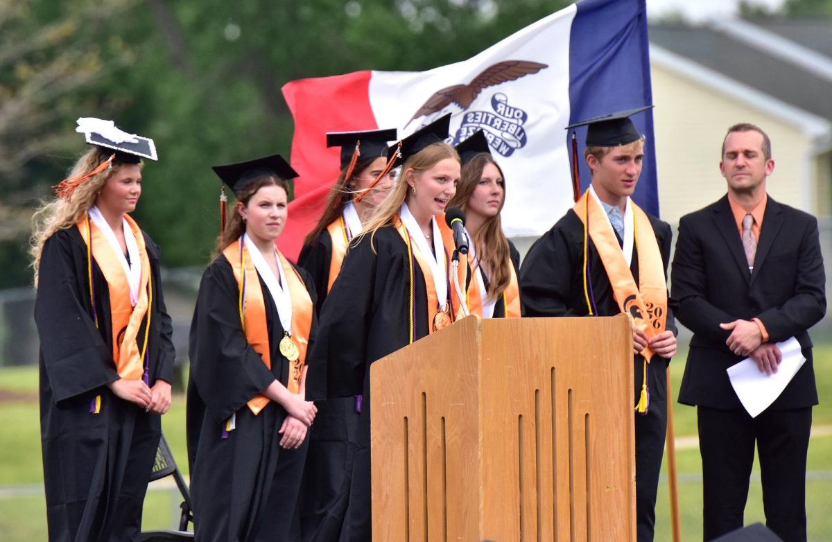 Dillon Ostrander, a Valedictorian, delivers remarks. Ostrander, Trea Eidahl (at left), Reese Grimm, and Layla Shipley spoke while joined on stage by fellow Valedictorians Cora Sutton and Teague Williams, and Solon High School principal Drew Bunkers.