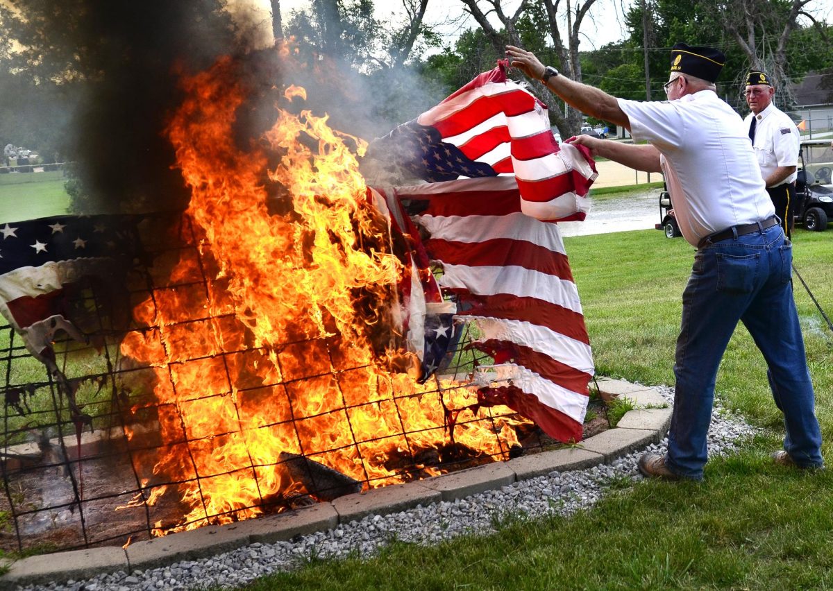 A member of Solon American Legion Stinocher Post 460 tries to avoid the intense heat as he places another unserviceable flag on a rack for burning during a flag retirement ceremony conducted by Solon American Legion Stinocher Post 460. This year’s ceremony is set for Sunday, June 14 (Flag Day) in Legion Park.